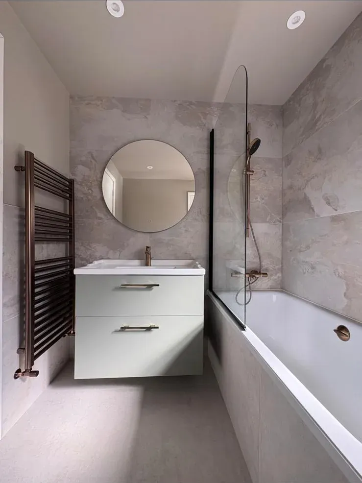 Marble bathroom with bath by Prestige Tiling