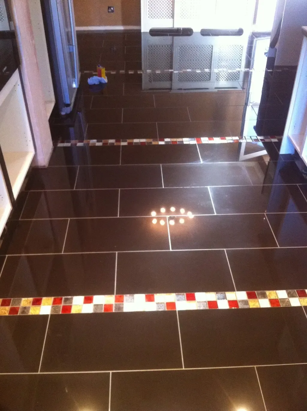 Gloss floor with mosaic border by Prestige Tiling