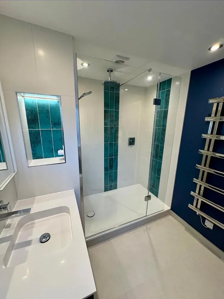 White bathroom, teal feature by Prestige Tiling